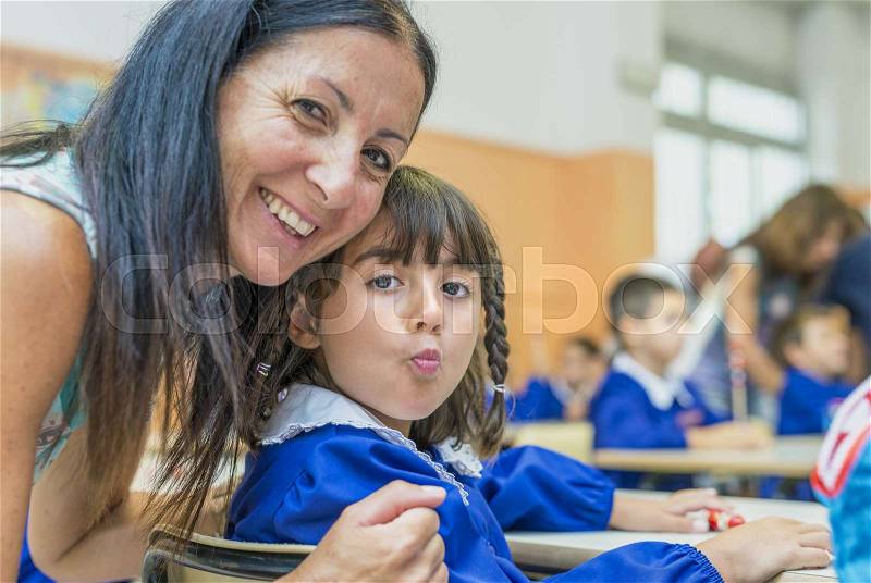 Young girl at elementary school for first day of lessons. Portrait with mother, stock photo