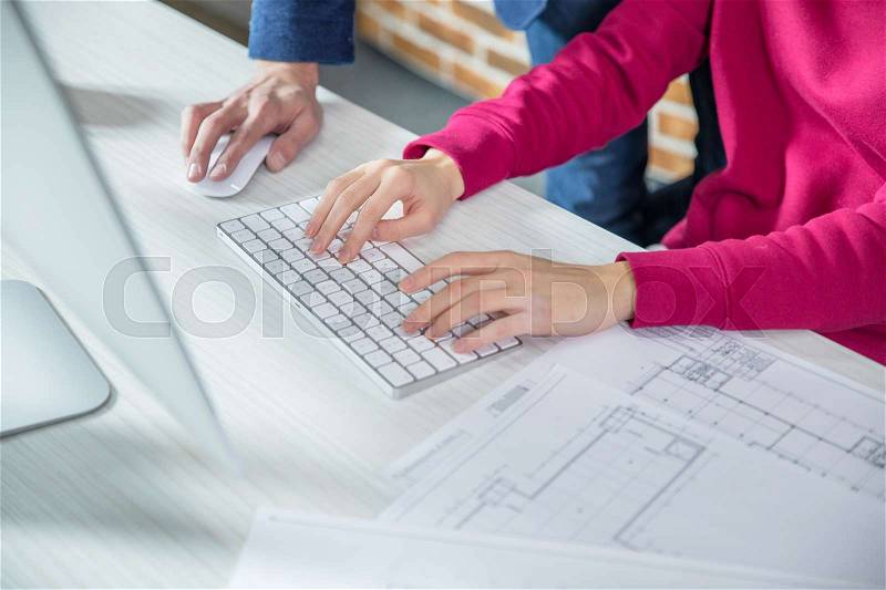 Partial view of man and woman working on computer, stock photo