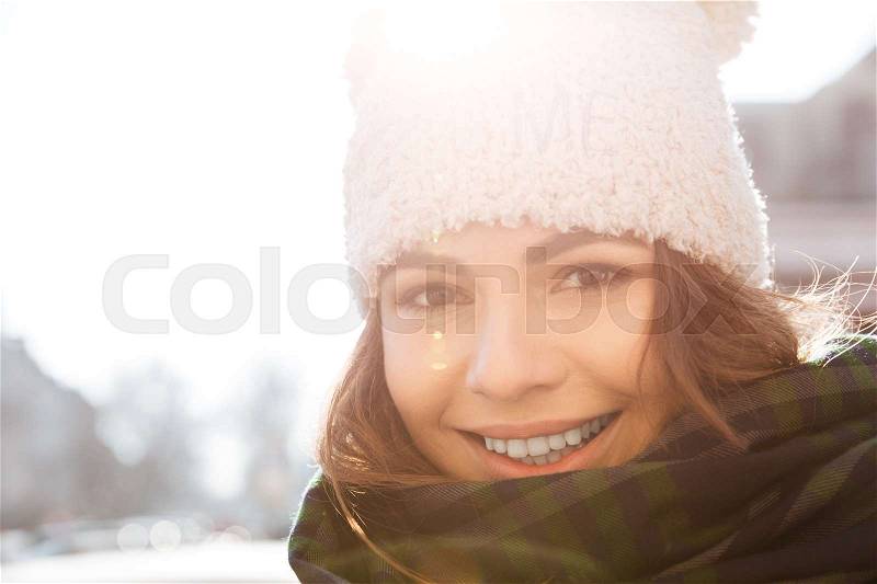 Picture of attractive young woman walking on the street wearing hat and scarf, stock photo