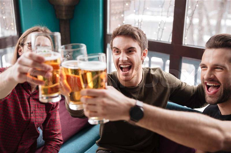 Image of happy men friends sitting in cafe while eating and drinking beer, stock photo