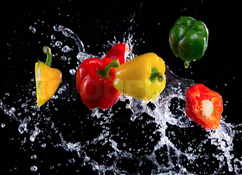 Bell peppers peppers with splash isolated on black background, motion action, stock photo