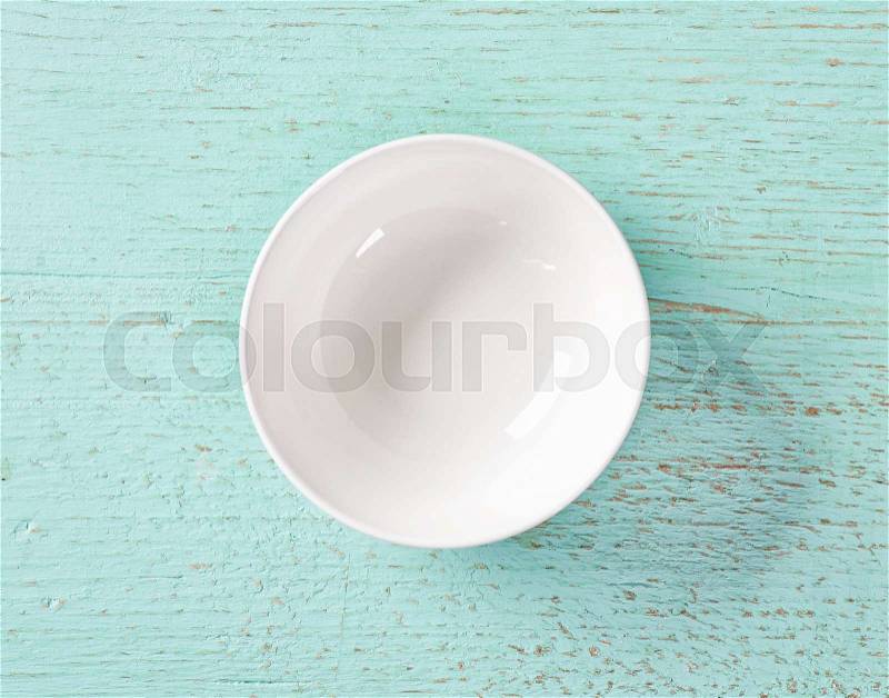 White empty bowl on blue wood background, top view, stock photo