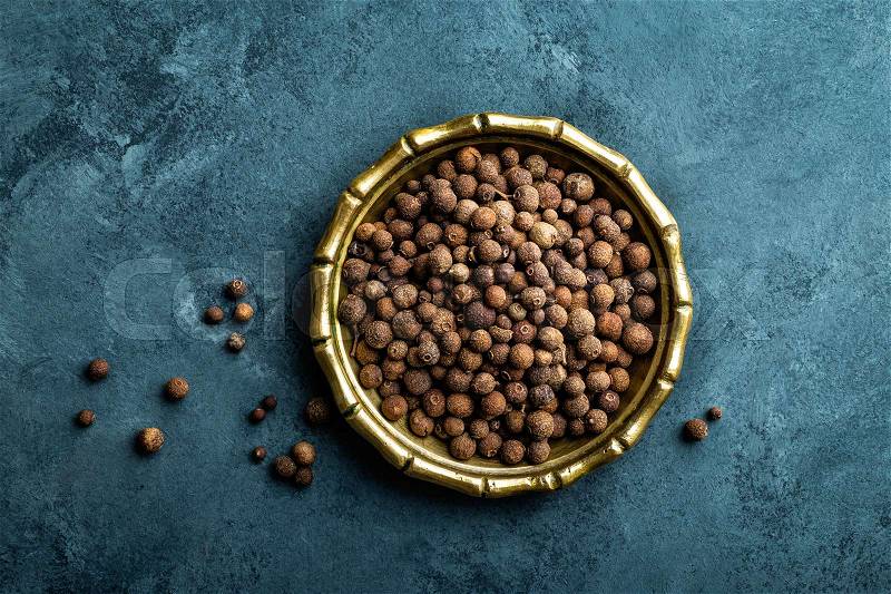 Allspice pepper, peppercorns on dark culinary background, top view, copy space, stock photo