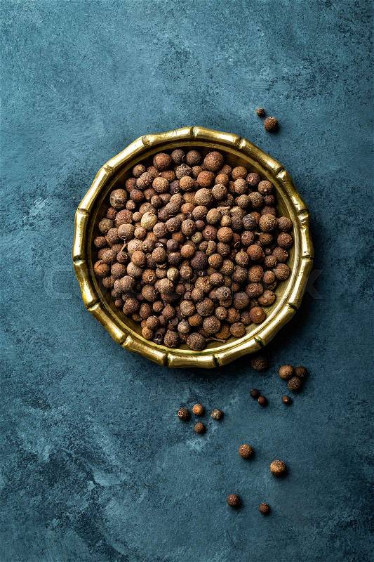 Allspice pepper, peppercorns on dark culinary background, top view, copy space, stock photo