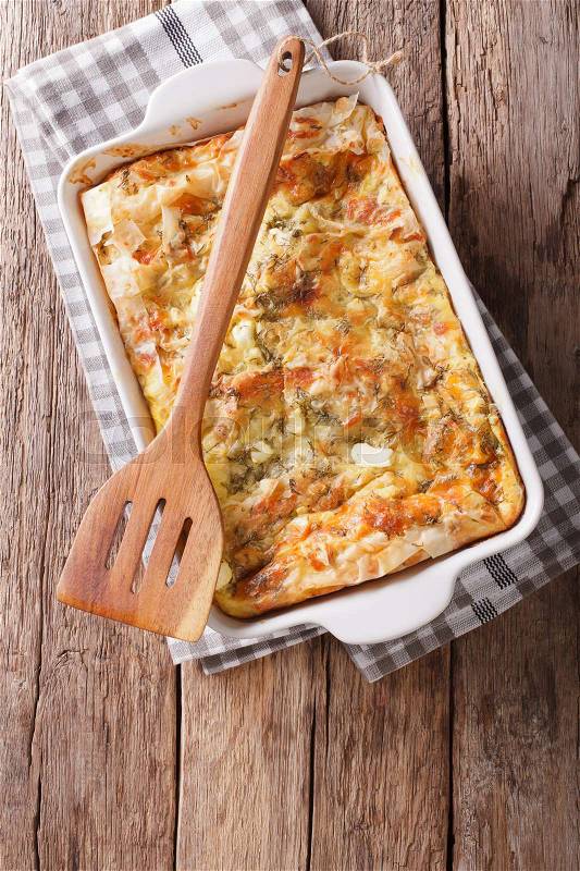 Serbian Gibanica from filo dough with cheese, eggs and greens close-up in a baking dish. Vertical view from above , stock photo