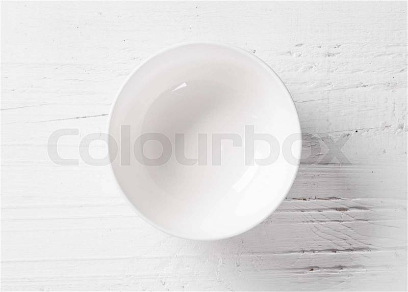 Empty bowl on white wooden table, top view, stock photo