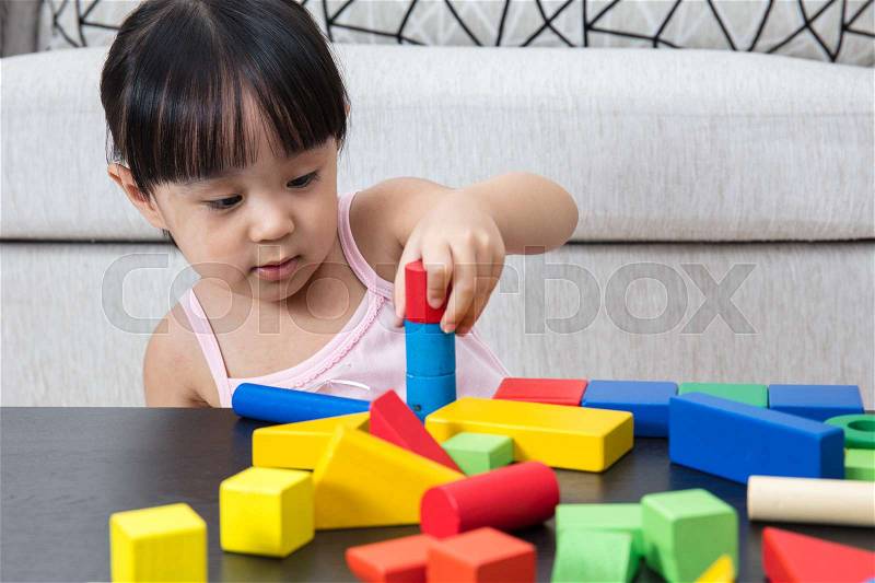 Asian Chinese little girl playing building blocks in the living room at home, stock photo