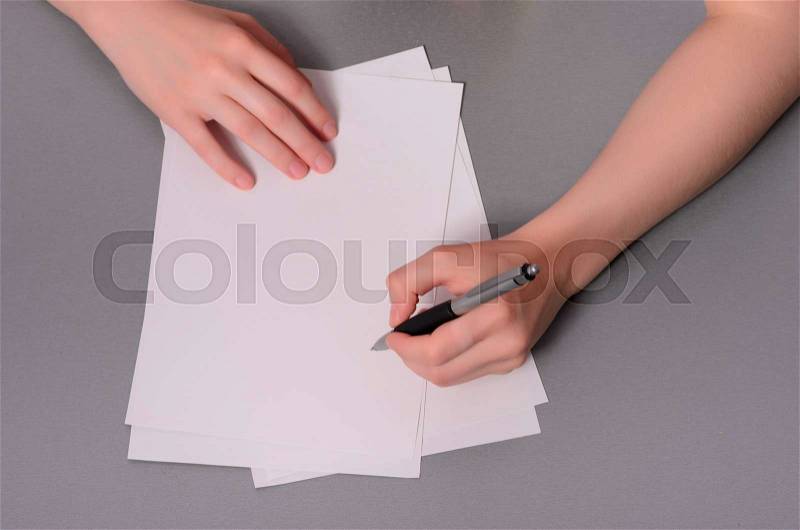 Human hands with pencil writing on paper and erase rubber on wooden table background, stock photo