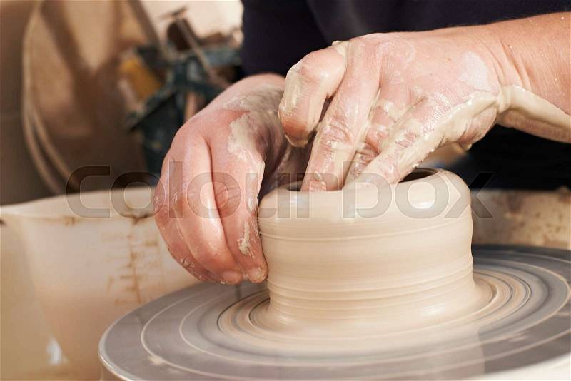 Close Up Of Potter Moulding Clay On Wheel, stock photo