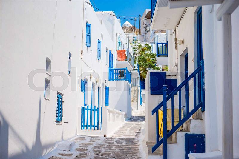 Empty narrow streets of greek island with trees. Beautiful architecture building exterior with cycladic style, stock photo