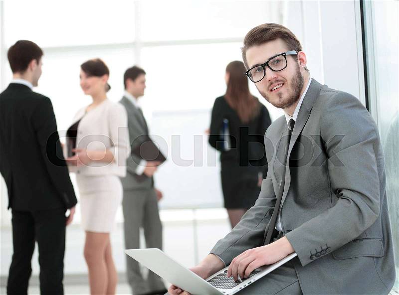 Closeup of a businessman in glasses sits with the laptop on the background of the office . the photo has a empty space for your text, stock photo