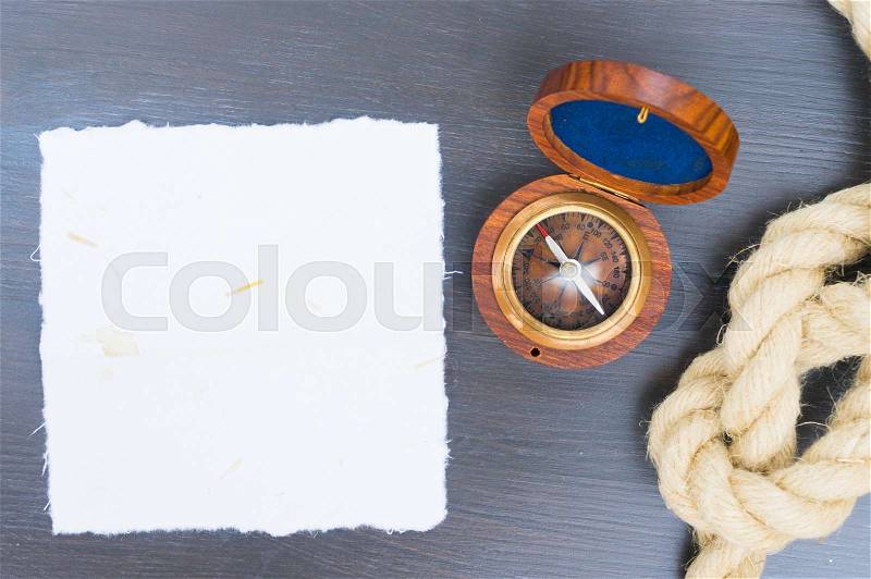 Old vintage compass with rope, copy space on white paper, stock photo