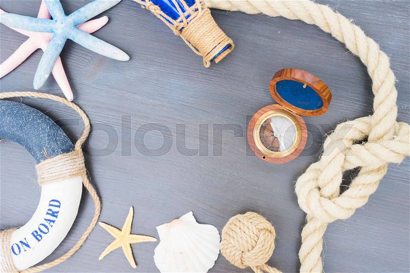 Old vintage compass with marine knot, life-ring and seastars with copy space, stock photo
