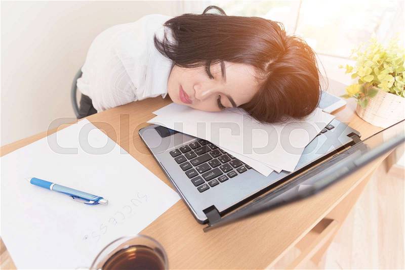 Young tired woman at office desk sleeping with eyes closed sleep deprivation and stressful life concept. Hard work, stock photo