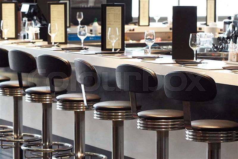 Bar stools and bar desk with glasses and menu cards, stock photo