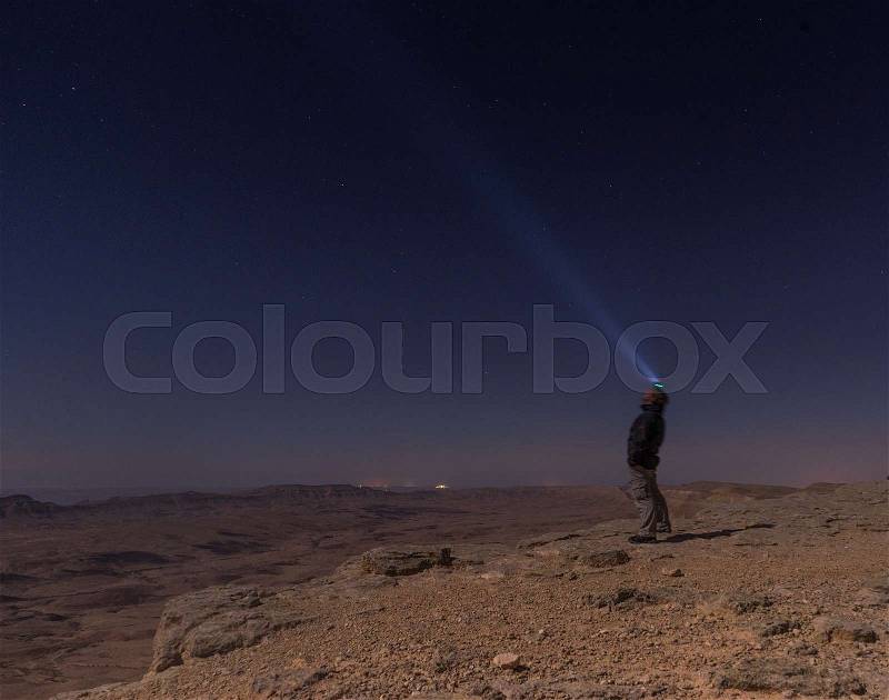 A man with light in night desert, stock photo