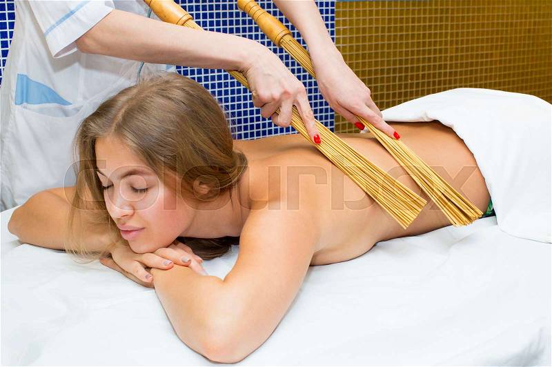 Japanese massage with bamboo sticks in spa salon, stock photo
