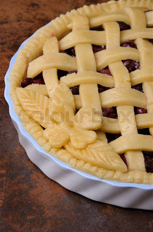 Cherry pie dough with decorative ornaments in roasting pan close-up, stock photo