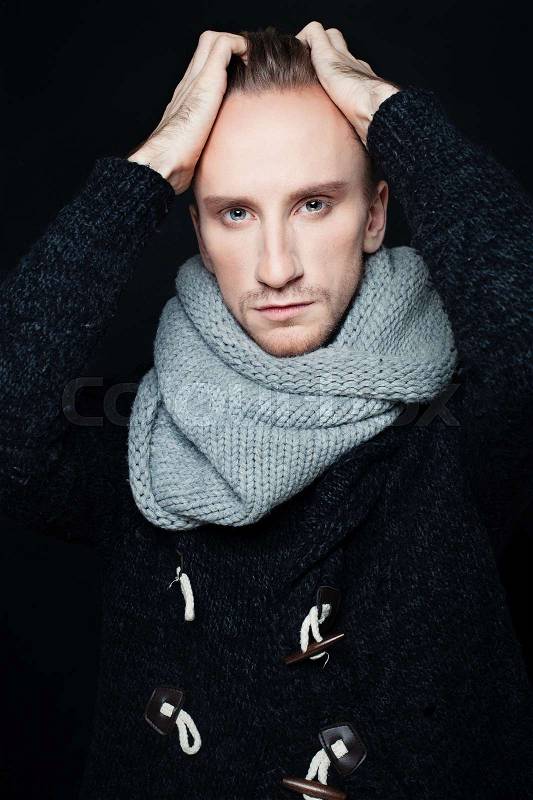 Man Fashion Model with Woolen Scarf on Dark Background, stock photo