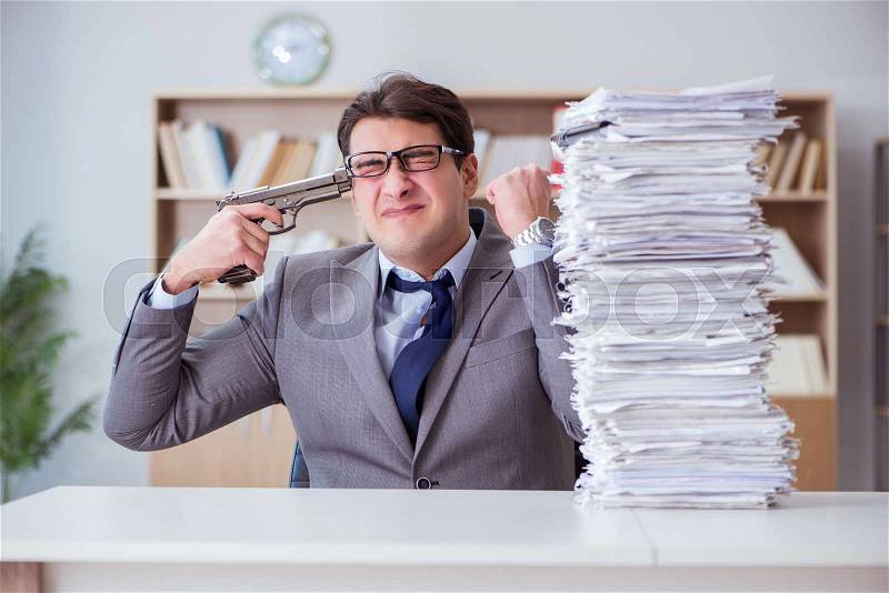 Businessman busy with paperwork in office, stock photo