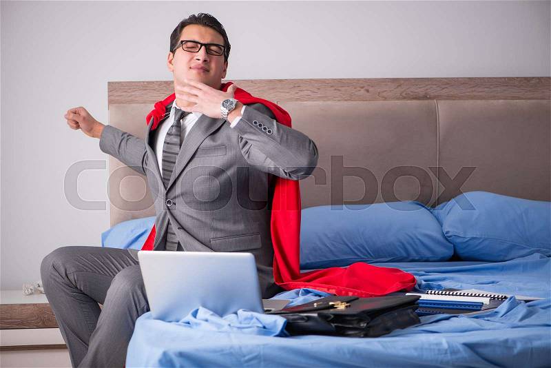 Super hero businesswoman working in bed, stock photo