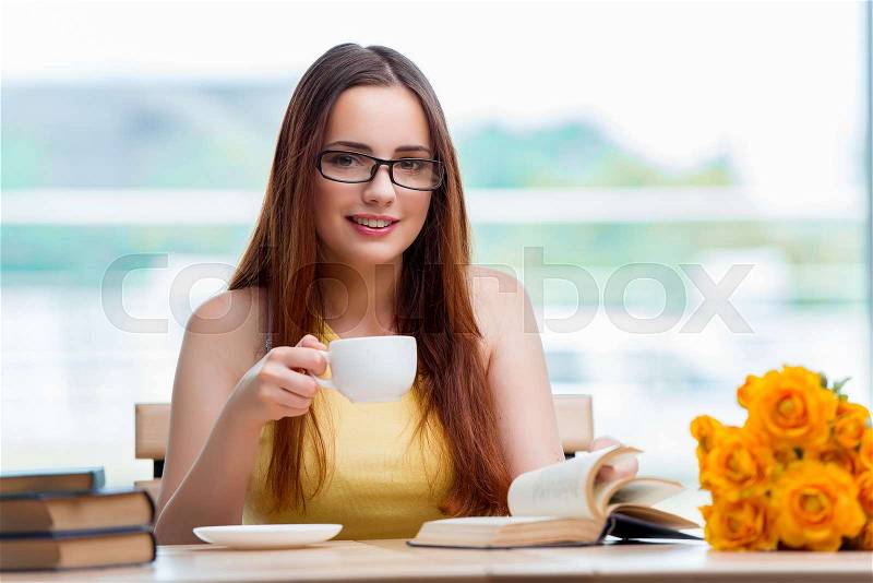 Young student drinking coffee while sudying, stock photo
