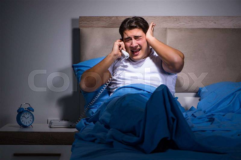 Young man struggling from noise in bed, stock photo