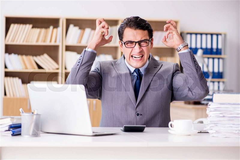 Angry businessman with too much work in office, stock photo