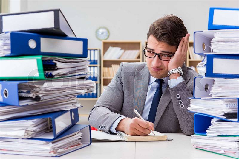 Busy businessman under stress due to excessive work, stock photo