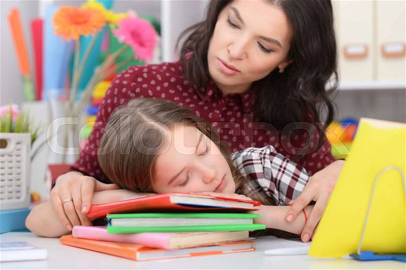 Portrait of a mother helping her daughter with lessons, stock photo