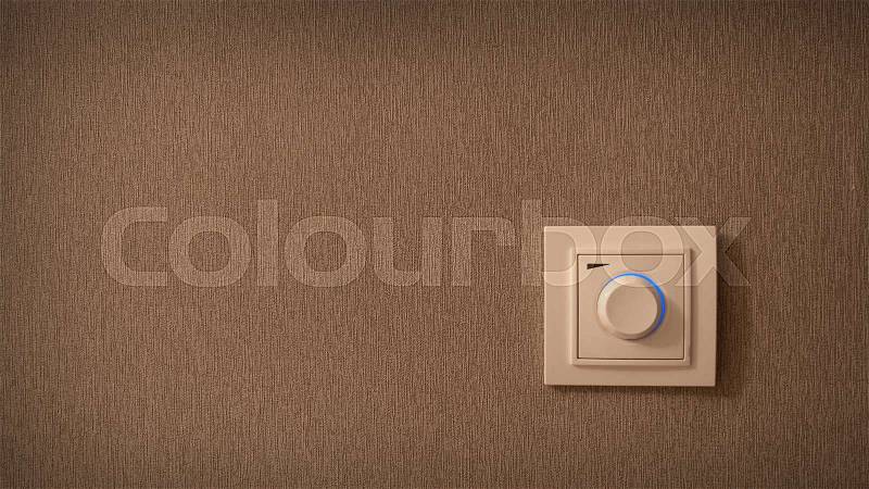 Switch button on the wall. Electrical round light switch on the wall, stock photo