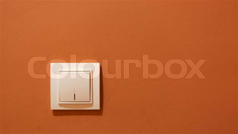White switch button on the wall. Electrical light switch on the wall, stock photo