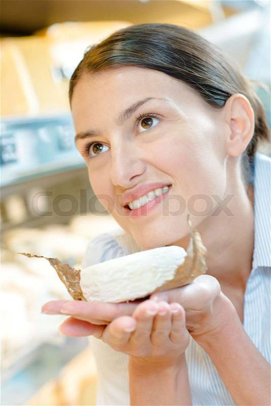 Lady smelling aroma from cheese, stock photo