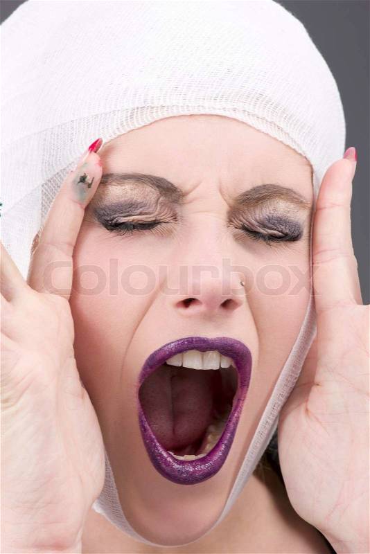 Picture of screaming wounded woman face over grey, stock photo