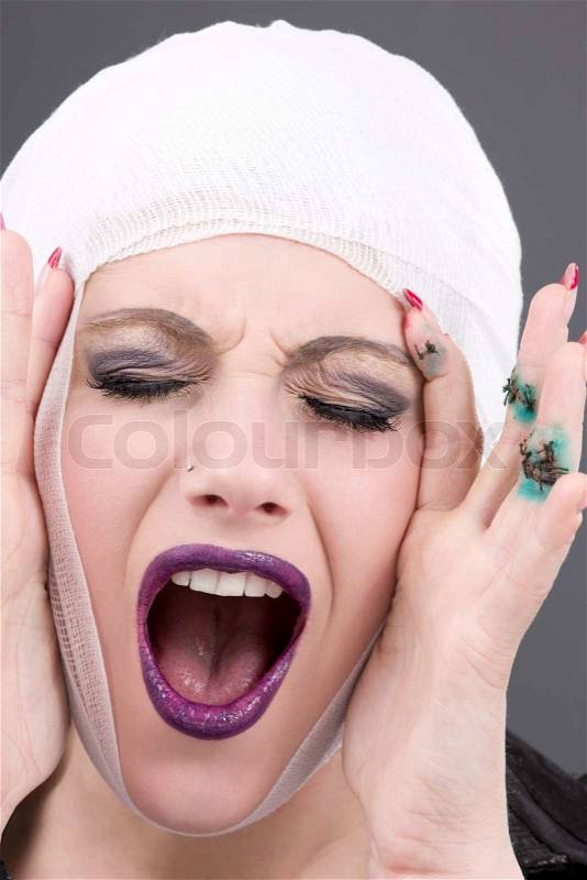 Picture of screaming wounded woman face over grey, stock photo