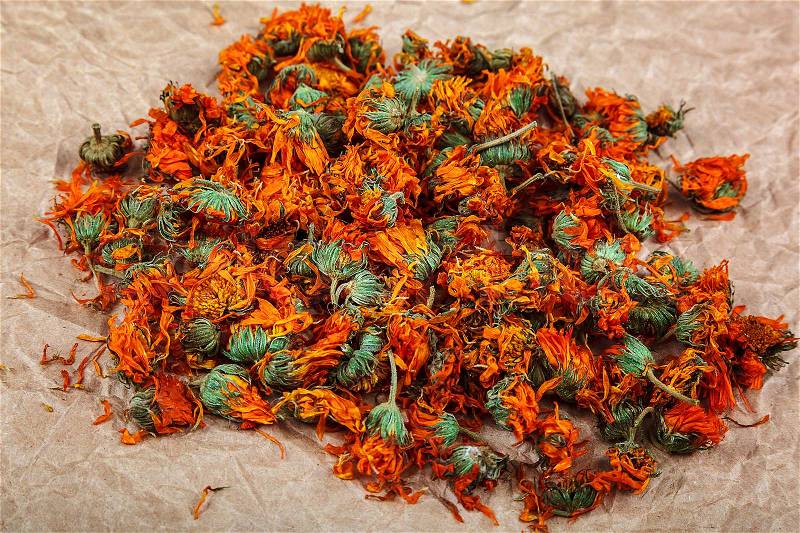 Dried calendula flowers on paper background. Medicinal plants, stock photo