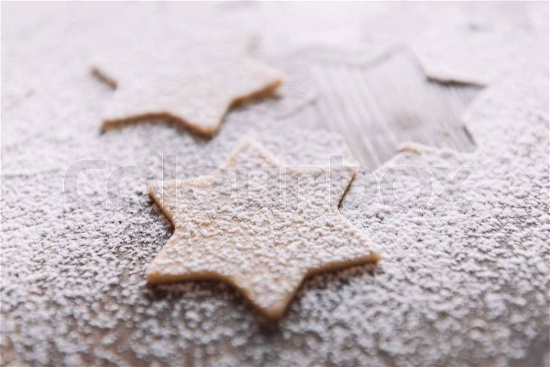 \'Close-up view of unbaked star shaped cookies in flour on table , stock photo