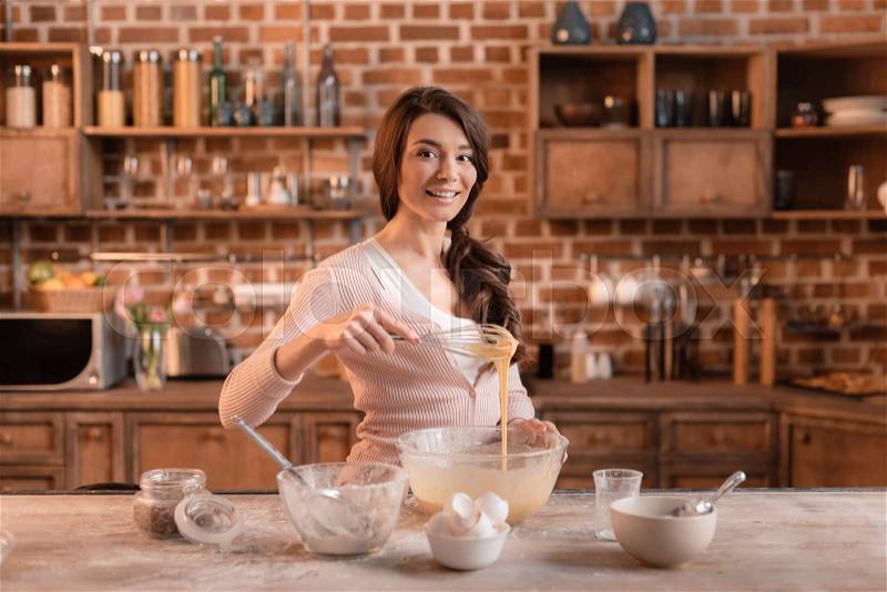 \'portrait of smiling woman mixing ingredients for cake, stock photo