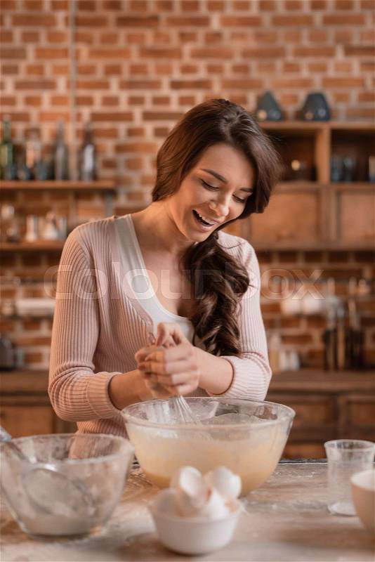 \'portrait of smiling woman mixing ingredients for cake, stock photo