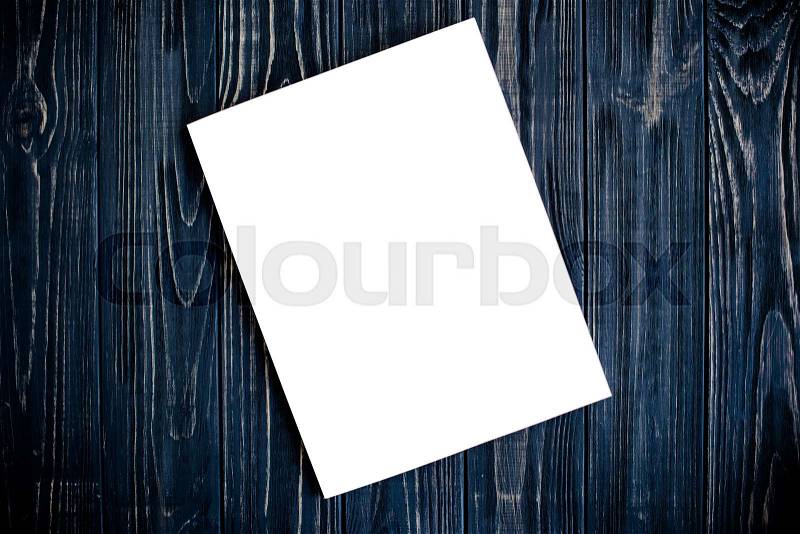 White isolated magazine cover mock-up on black wooden table board background, stock photo
