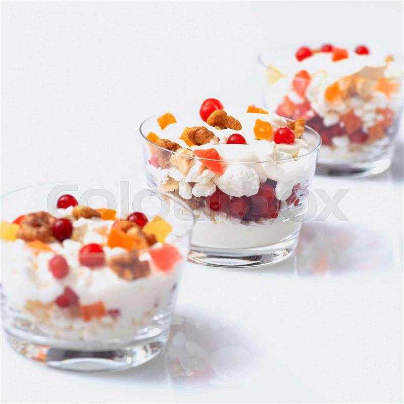 Glass jars with cream cheese and sour cream, cranberries and candied fruit, stock photo