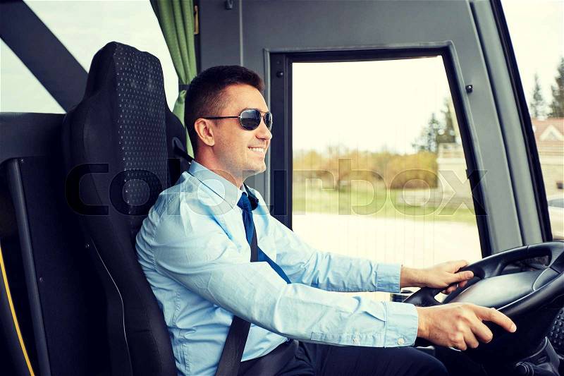 Transport, tourism, road trip and people concept - happy driver driving intercity bus, stock photo