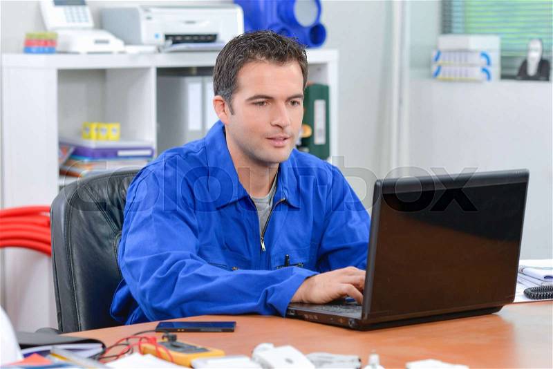Builder using a laptop computer, stock photo