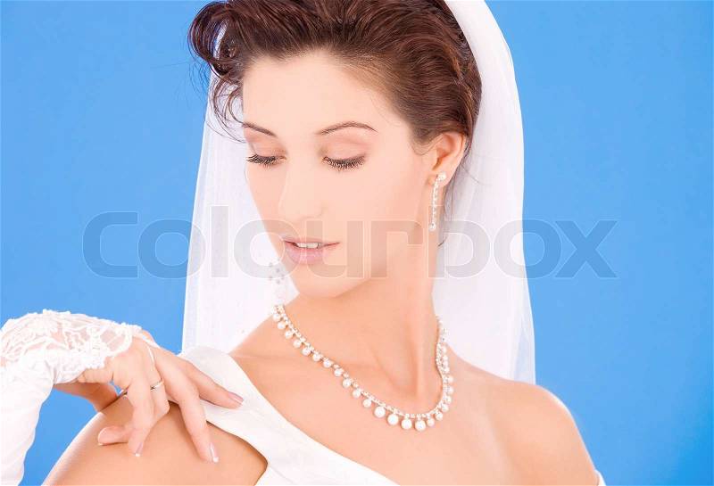Happy bride with her wedding ring over blue, stock photo