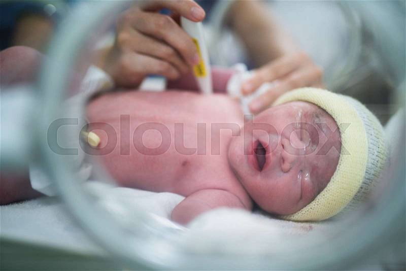 Body temperature check for new born baby in hospital, mother and baby concept, stock photo
