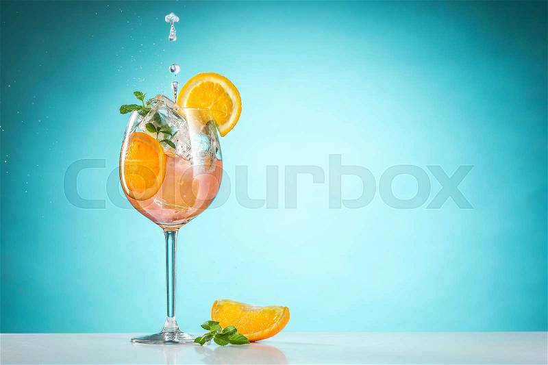 The rose exotic cocktail and fruit on table, against blue, stock photo