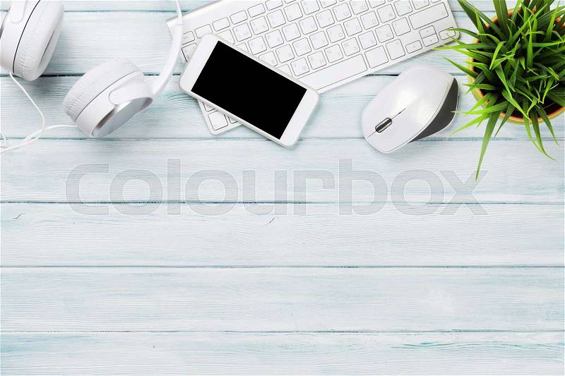Headphones, phone and pc on wooden desk table. Top view with copy space, stock photo