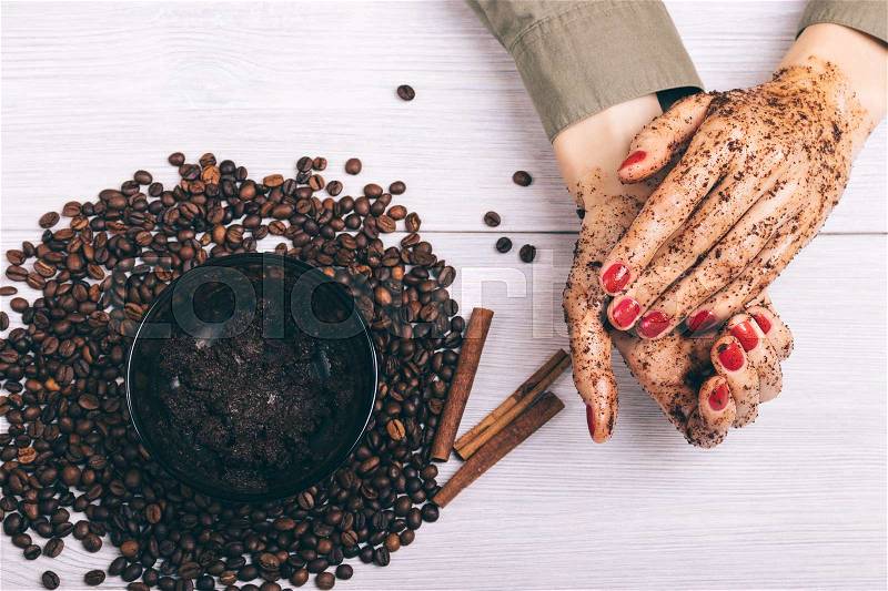Closeup of female hands and the coffee scrub, top view, stock photo