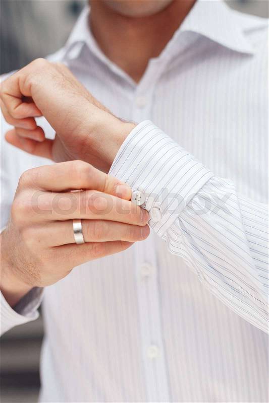 Close up of a hand businessman how wears white shirt and cufflink. Elegant white shirt with buttons, stock photo