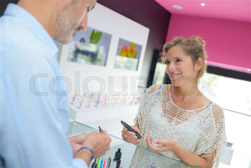 Shop assistant and customer at shop counter, stock photo